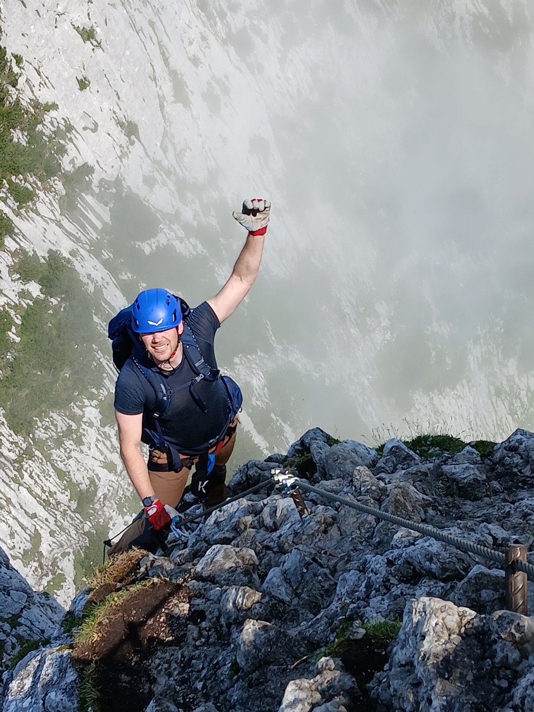 Klettersteiggeher jubelt hoch über dem Nebelmeer am Donnerkogel